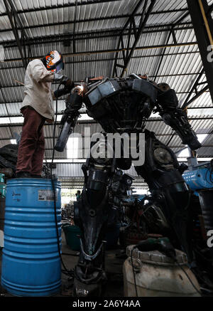 Angthong, Thaïlande. 26Th Oct, 2019. Un métallier vu soudure d'une statue de Transformers à Ban Hun Lek, un atelier de ferronnerie réputé pour statues géantes de transformateurs, Hulk et autres icônes pop, dans la province de Thai central Angthong. Credit : SOPA/Alamy Images Limited Live News Banque D'Images
