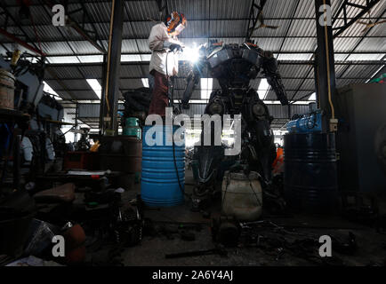 Angthong, Thaïlande. 26Th Oct, 2019. Un métallier vu soudure d'une statue de Transformers à Ban Hun Lek, un atelier de ferronnerie réputé pour statues géantes de transformateurs, Hulk et autres icônes pop, dans la province de Thai central Angthong. Credit : SOPA/Alamy Images Limited Live News Banque D'Images