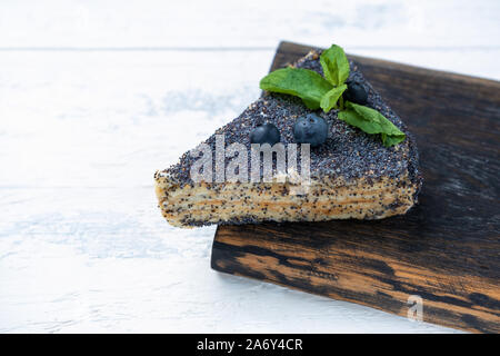 Un morceau de gâteau aux graines de pavot avec des bleuets Banque D'Images