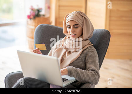 Femme avec des yeux sombres faisant des emplettes en ligne Banque D'Images