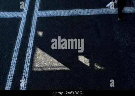 Des géométries et des lignes sur un pavé d'une rue Banque D'Images