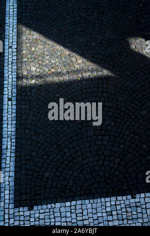 Des géométries et des lignes sur un pavé d'une rue Banque D'Images