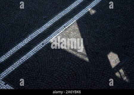 Des géométries et des lignes sur un pavé d'une rue Banque D'Images