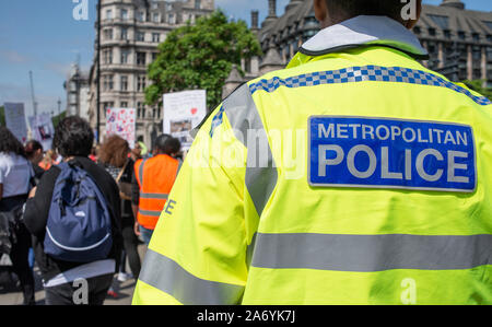 Le policier observe à distance, tandis qu'une manifestation de protestation "opération Shutdown" a lieu aux portes de la Chambre du Parlement, Londres Banque D'Images