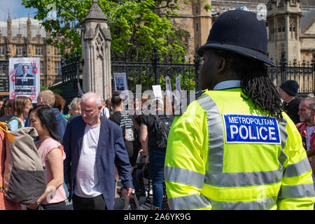 Le policier regarde à distance, car une manifestation de protestation "opération Shutdown" a lieu aux portes de la Chambre du Parlement à Londres. Banque D'Images