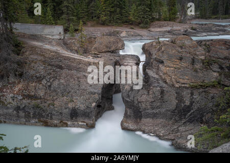 Une longue exposition photo de bonne voie lactée d'une chute d'eaux pinçant par une étroite ouverture rock dans le Parc National de Jasper, Canada Banque D'Images