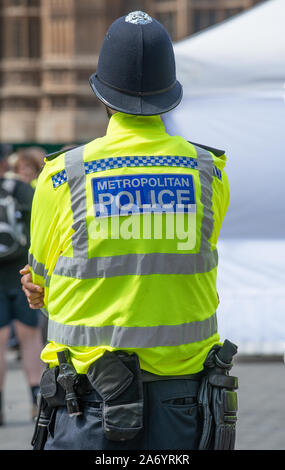 Le policier, avec son dos à la caméra, se tient à regarder à proximité de la tente des organisateurs de la manifestation sur le changement climatique, par la Chambre du Parlement, Londres. Banque D'Images