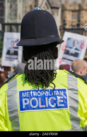 Le policier observe à distance, tandis qu'une manifestation de protestation "opération Shutdown" a lieu aux portes de la Chambre du Parlement, Londres Banque D'Images