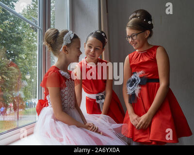 Vitebsk-Belarus. L'Est de l'Europe-September 19, 2019 : trois filles de moins de 15 ans habillé en robe de soirée rouge vif communiquer lors d'un b Banque D'Images