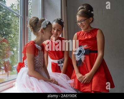 Vitebsk-Belarus. L'Est de l'Europe-September 19, 2019 : trois filles de moins de 15 ans habillé en robe de soirée rouge vif communiquer lors d'un b Banque D'Images