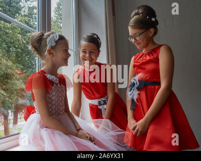 Vitebsk-Belarus. L'Est de l'Europe-September 19, 2019 : trois filles de moins de 15 ans habillé en robe de soirée rouge vif communiquer lors d'un b Banque D'Images
