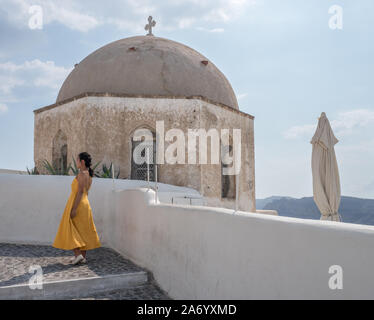 Un profil de jeune femme asiatique slim par permanent Profil mur blanc chapelle de l'église sous ciel bleu avec destination cloud Oia Santorini Banque D'Images