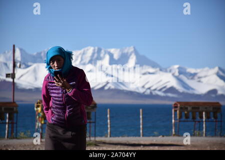 Nomad femme marche à proximité de la plage dans le Lac Namtso, Tibet - Chine Banque D'Images