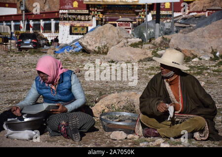 Deux nomades tibétains assis sur le sol à proximité du Lac Namtso, Tibet - Chine Banque D'Images