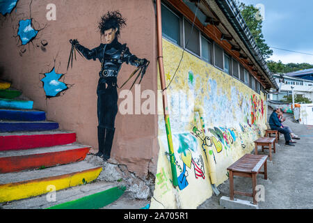 La Corée Jeonju , 6 octobre 2019 : Jaman village avec fresque murales colorées et des gens assis sur un banc à Jeonju, Corée du Sud Banque D'Images