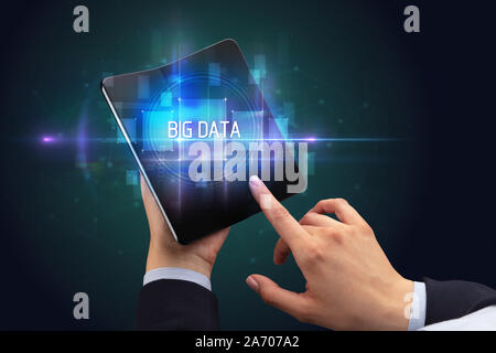 Businessman holding un smartphone avec le BIG DATA, la nouvelle technologie d'inscription concept