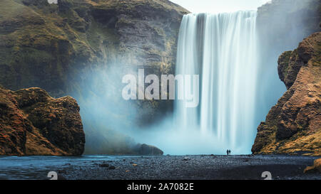 Couple d'près de la célèbre cascade de Skogafoss, Islande Banque D'Images