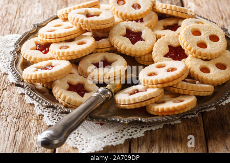 Cookies savoureux sandwich avec de la confiture. Des pâtisseries autrichiennes traditionnelles Linzer. Gros plan sur une assiette sur la table horizontale. Banque D'Images