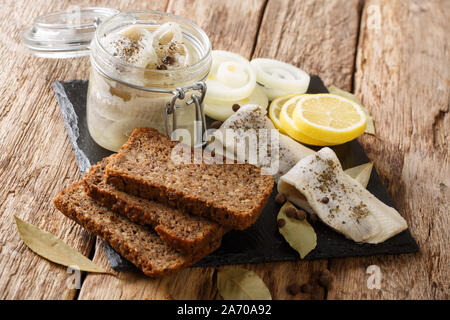 Recette de harengs marinés avec des oignons, du vinaigre, des épices dans l'huile dans une banque close-up sur la table horizontale. Banque D'Images