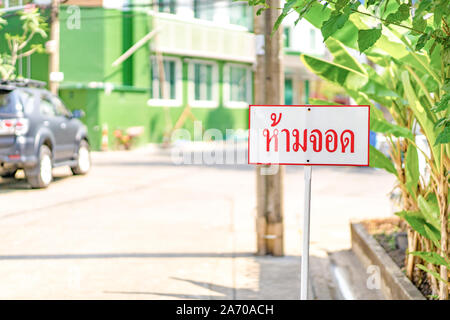 La Thaïlande signe aucun stationnement' veille à côté de la route dans la région de vilage de Bangkok. Le texte thaï signifie "no parking". Banque D'Images