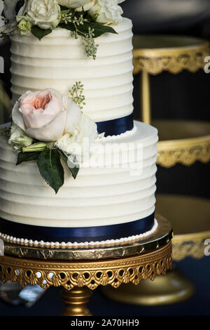 Close up of white deux niveaux gâteau de mariage avec des fleurs. Banque D'Images