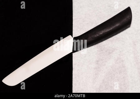 Couteau en céramique noir et blanc sur un fond noir et blanc inhabituel Banque D'Images