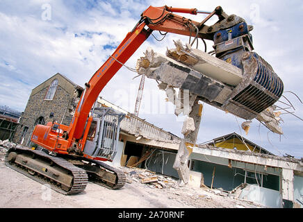 Guernesey. L'industrie. Démolition de bâtiment. La machine excavatrice au travail. Banque D'Images