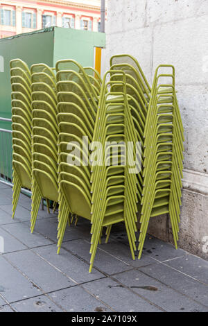 Des chaises en métal vert superposés à l'avant du restaurant Banque D'Images