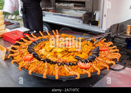 Paella de fruits de mer et le riz étant cuit dans une grande casserole, marché plein air à Neufchâtel-en-Bray, Normandie, France Banque D'Images