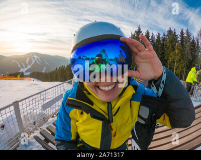 Les amis s'amusant de prendre photo sur le haut de la colline de neige. reflet dans les lunettes. Ski et snowboard Banque D'Images