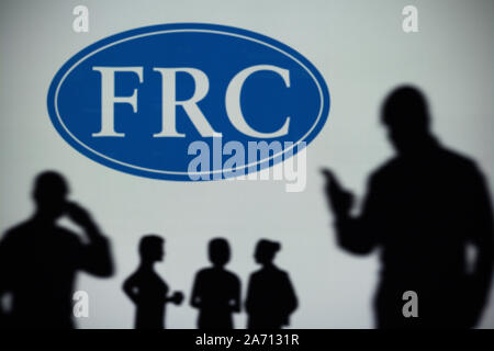 Le CEAF (Financial Reporting Council logo est visible sur un écran LED à l'arrière-plan tandis qu'une silhouette personne utilise un smartphone (usage éditorial uniquement) Banque D'Images