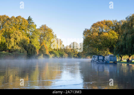 Les arbres d'automne et narrowboats le long d'une rivière en crue avon sur un matin d'automne. Stratford Upon Avon, Warwickshire, Angleterre Banque D'Images