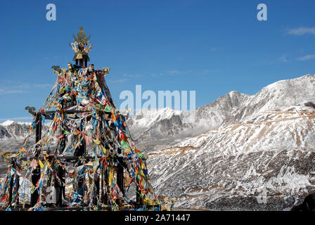 Drapeaux de prière à un point sur le col zheduo Sichuan en Chine avec les montagnes de la gamme Daxueshan en arrière-plan Banque D'Images