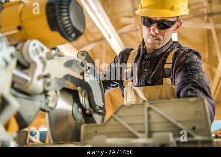 Young Entrepreneur en construction dans la trentaine qui travaillent avec l'outil de puissance. Scie à bois circulaire puissant. Thème industriel. Banque D'Images