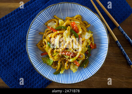 La photographie culinaire d'un bol japonais avec yaki Udon noodles sur un tissu bleu. Banque D'Images