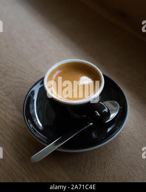 Machiato Espresso latte en forme de coeur avec art sur un comptoir en bois Banque D'Images