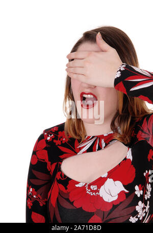 Une jeune belle femme debout dans le studio pour fond blanc criant, avec une main sur ses yeux Banque D'Images