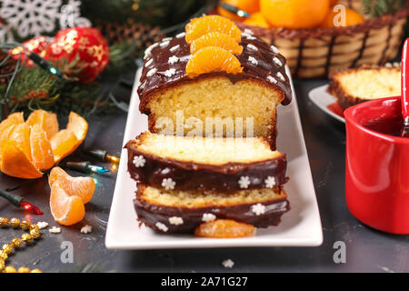 Cupcake avec mandarine, le couvert de glace au chocolat est situé sur le Nouvel An ou Noël arrière-plan Banque D'Images