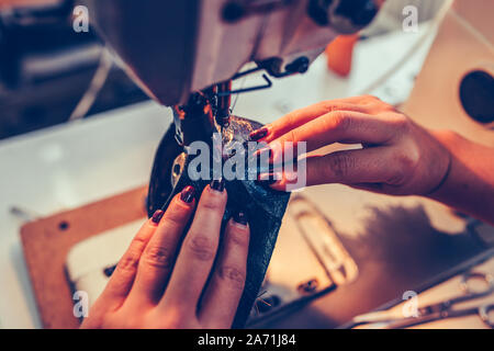 Close up une femme couture mains cordonnier un partie de la chaussure lors d'un atelier Banque D'Images