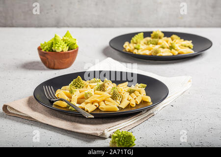 Pâtes penne avec du chou romanesco sur fond gris clair Banque D'Images