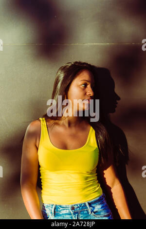 Portrait de jeune femme à la recherche de côté et debout dans la rue.J Banque D'Images