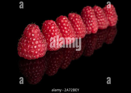 Groupe des sept entiers et frais, framboise rouge isolé sur verre noir Banque D'Images