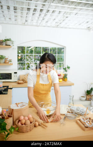 Fissuration femme oeufs dans le bol en verre Banque D'Images