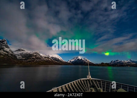 Les aurores boréales dans l'arc de lune sur le détroit d'Rafsundet près de l'entrée du Trollfjord en Norvège. C'est à partir du pont de la ms Banque D'Images