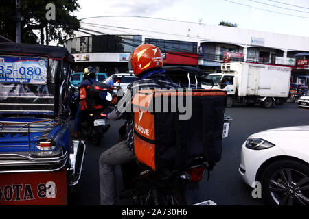 ANTIPOLO CITY, PHILIPPINES - 21 octobre 2019 : delivery man moto de route autour d'un trafic routier congestionné. Banque D'Images