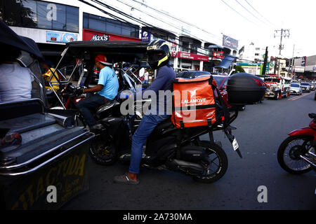 ANTIPOLO CITY, PHILIPPINES - 21 octobre 2019 : delivery man moto de route autour d'un trafic routier congestionné. Banque D'Images