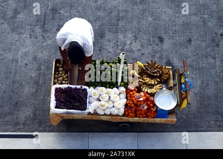 ANTIPOLO CITY, PHILIPPINES - 25 octobre 2019 : vendeur vend Fruits Fruits frais assortis dans son panier alimentaire et attend les clients à un trottoir. Banque D'Images