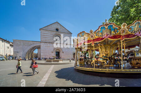 Giostra Antica merry-go-round sur la Piazza Santa Chiara avec vue sur la façade de la Basilique de Santa Chiara, assise, Ombrie, Italie Banque D'Images