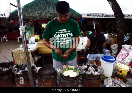 ANTIPOLO CITY, PHILIPPINES - 28 octobre 2019 : vendeur alimentaire cuisiniers Bibingka ou glutenous gâteau de riz à sa nourriture, wc séparés. Banque D'Images