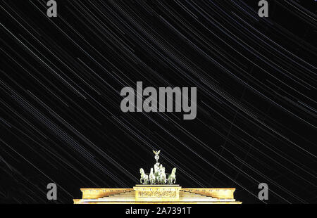 Berlin, Allemagne. 29 Oct, 2019. Les étoiles apparaissent comme des bandes dans le ciel au-dessus de la porte de Brandebourg. (Tir à longue exposition) Crédit : Paul Zinken/dpa/Alamy Live News Banque D'Images